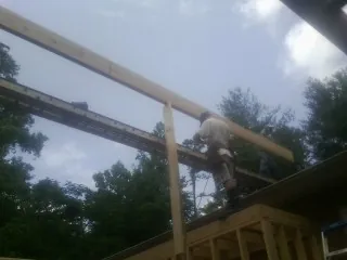 Carpenter setting a ridge beam over a new addition frame — Ice Dam Removal by Roofing Brothers in Toone