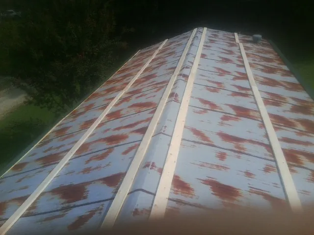 Rusted metal roof panels with new wood purlins before replacement — Storm Damage Roof Repair in Toone by Roofing Brothers