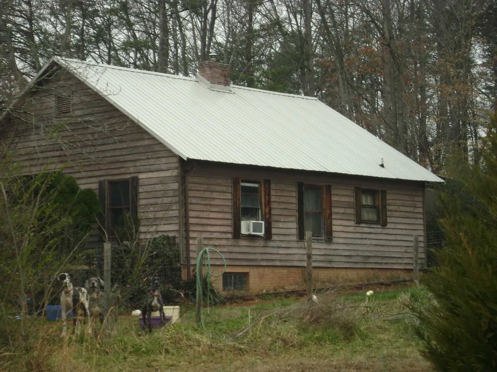White metal roof on an old wood sided farmhouse, from a Metal Roof Installation job in Toone